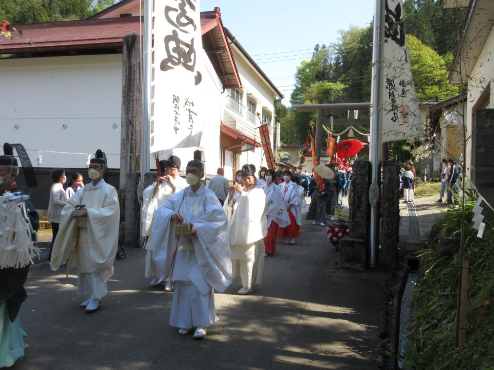 小川神社の御柱祭 鳥居をくぐる御柱の行列の写真